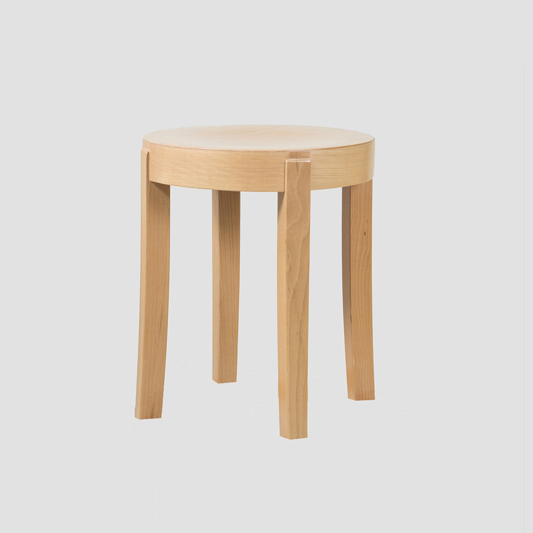 A natural finish low stool with a profiled seat and flared legs, constructed from European Beech wood.