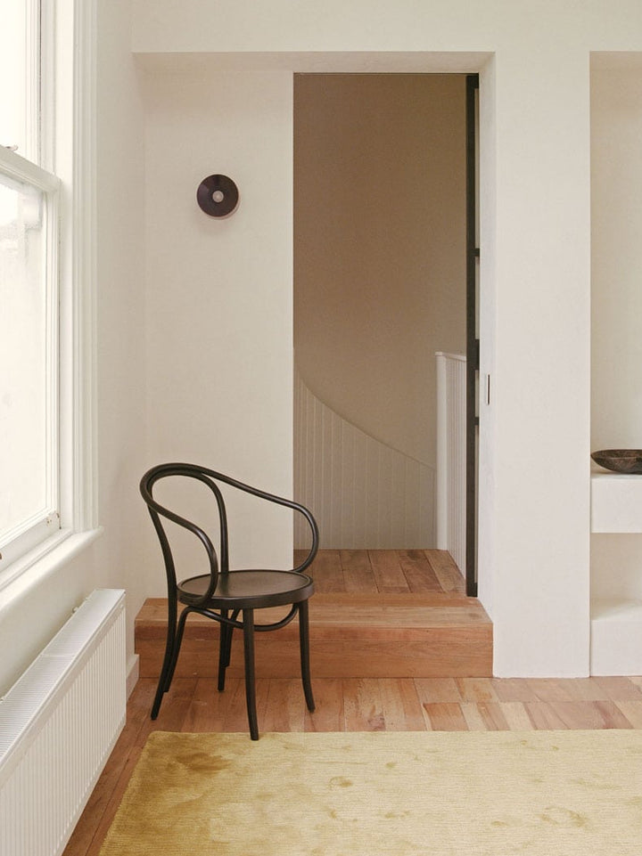 Modern interior with a black chair near a window and a door.